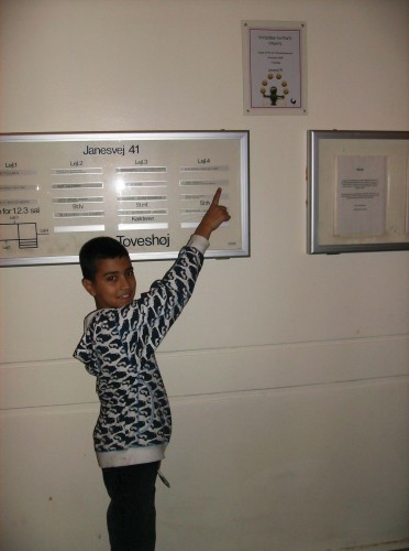 trin-for-trin-diplom-005 Younes på 10 år peger på vinderskiltet i opgangen på Janesvej 41
