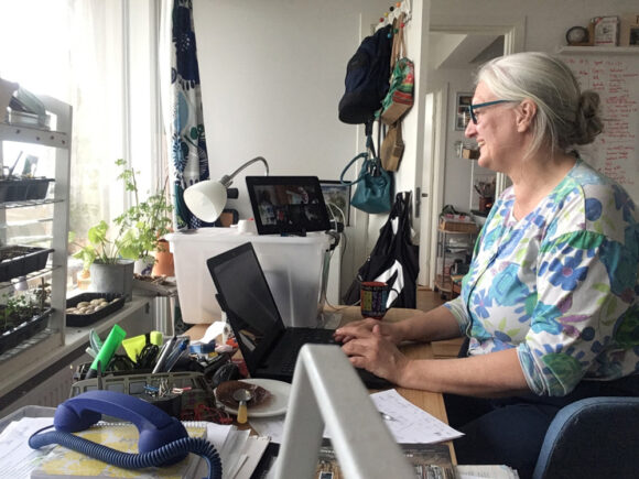 Skræppebladets redaktør, Helle Hansen, sidder på sit hjemmekontor og forsøger at styre talerækken på redaktionsmødet i cyberspace.