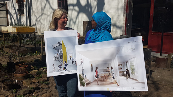 Anett og Ilham viser plancherne frem i Laden solrige have.
